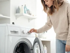 Jasnoszara opaska z płyt betonowych wokół nowoczesnego domu, z ozdobnymi kamieniami przy ścianie i zadbanym trawnikiem.